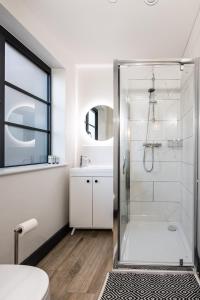 een witte badkamer met een douche en een wastafel bij 2 Castle Mews in Salisbury