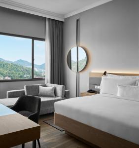 AC Hotel by Marriott Penang في بايان ليباس: غرفه فندقيه بسرير واريكه