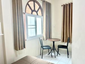 a room with a table and two chairs and a window at PD Hostel in Ban Don Muang (1)