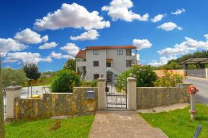 una casa con un cancello e una recinzione in pietra di Apartments Djordjo 2295 a Banjole