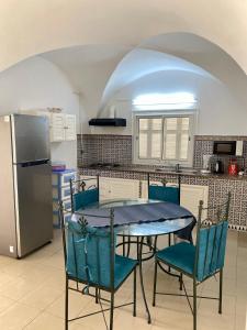 BUNGALOW El HOUDA في الحمامات: مطبخ مع طاولة وكراسي وثلاجة