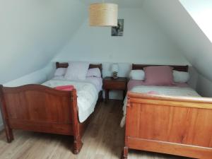 2 Einzelbetten in einem Zimmer mit 2 Tischen in der Unterkunft Gîte Ty Loguellou in Locmélar