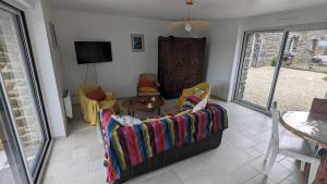 ein Wohnzimmer mit einem Sofa und einem Tisch in der Unterkunft Gîte Ty Loguellou in Locmélar