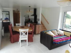 a living room with a table and a couch at Gîte Ty Loguellou in Locmélar