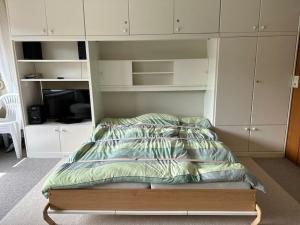 a bed in a bedroom with white cabinets at Ruhige Ferienwohnung in Schönwald in Schönwald