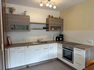 a kitchen with white cabinets and a sink at Ruhige Ferienwohnung in Schönwald in Schönwald