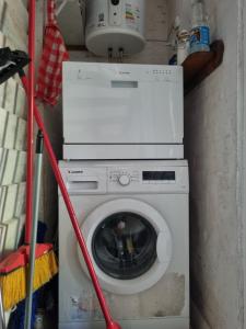 a washing machine with a red hose attached to it at Casa bosque y mar in Ocean Park