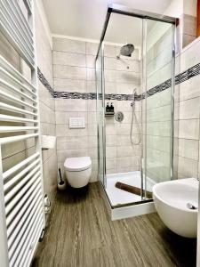 y baño con ducha, aseo y lavamanos. en Il Nido delle Cime - 5 minuti a piedi dalle Terme - Parcheggio Gratuito, en Bormio