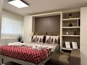 1 dormitorio con 1 cama con manta roja y blanca en Il Nido delle Cime - 5 minuti a piedi dalle Terme - Parcheggio Gratuito, en Bormio