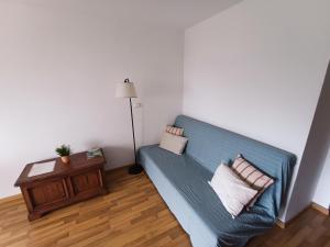 un soggiorno con divano blu e tavolo di Piso moderno con piscina Siesta 2 a Port d'Alcudia