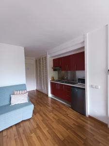 a small apartment with red cabinets and a kitchen at Piso moderno con piscina Siesta 2 in Port d'Alcudia