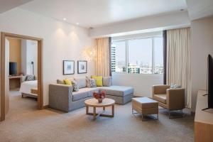 Doubletree By Hilton Fujairah City في الفجيرة: غرفة معيشة مع أريكة وطاولة