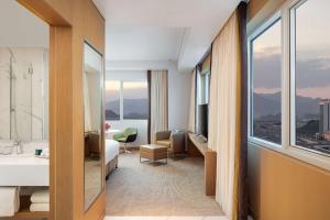 a hotel room with a bed and a bathroom with a view at Doubletree By Hilton Fujairah City in Fujairah