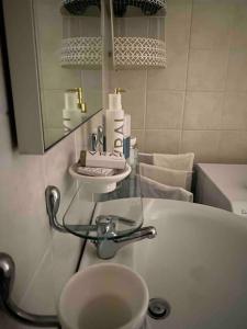 een badkamer met een wastafel en een spiegel bij Casa a schiera con giardino condominiale in Bella Farnia