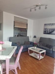 a living room with a blue couch and a table at Sol y Luz in Isla del Moral