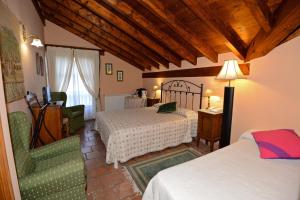 a hotel room with two beds and a chair at Hotel-Posada La Casa de Frama in Frama