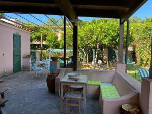 une terrasse avec un canapé, une table et des chaises dans l'établissement Villetta panoramica sul mare, à Procida