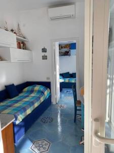 um quarto com uma cama e um piso azul em Villetta panoramica sul mare em Procida