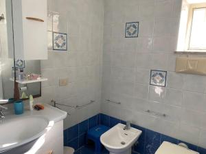uma casa de banho azul e branca com um lavatório e um WC em Villetta panoramica sul mare em Procida