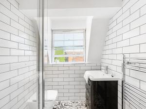 a white bathroom with a toilet and a sink at Serene 2BR Retreat in Bishop's Stortford in Bishops Stortford