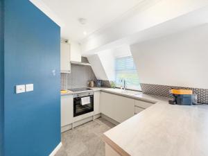 a kitchen with white cabinets and a blue door at Serene 2BR Retreat in Bishop's Stortford in Bishops Stortford