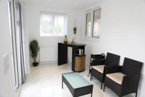 a living room with two chairs and a table at Vienna Orpington in Orpington