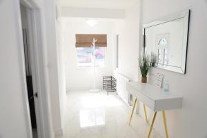 a white hallway with a desk and a mirror at Vienna Orpington in Orpington