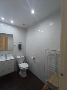 y baño blanco con aseo y ducha. en Piso moderno con piscina Siesta 2, en Puerto de Alcudia