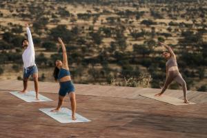 a group of people doing yoga on mats at Our Habitas Namibia in Dordabis