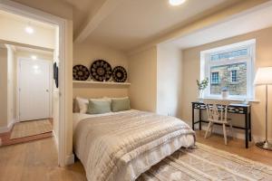 a bedroom with a bed and a desk and a window at Cosy, Cottage Style Apartment in Peak District in Glossop