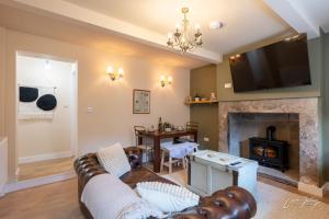 a living room with a couch and a fireplace at Cosy Cottage in Heart of Glossop in Glossop