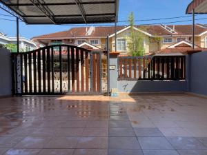 an open gate to a house with houses in the background at Comfy Sutera Seberang Jaya in Kampong Belah Dua