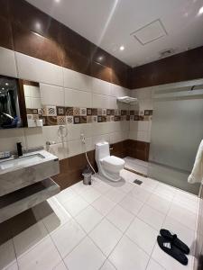 uma casa de banho com um WC, um lavatório e um chuveiro em فندق ركن النخبه الماسي Elite Diamond Corner - فنـــــــدق دامـاس Damas Hotel em Jeddah