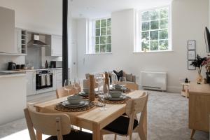 a kitchen and dining room with a wooden table and chairs at Apartment 1 Y Capel, Free on site parking, Central to town and a55 expressway in St Asaph