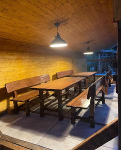 イェセニークにあるChata Vápennáの木製のテーブルとベンチが並ぶ部屋