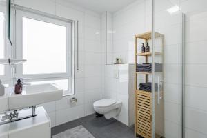 a white bathroom with a toilet and a sink at GT-City Suite 01 I Gasgrill I Smart-TV I Balkon in Gütersloh +20 photos