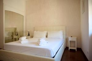 una camera da letto con un letto bianco con due asciugamani sopra di Riboty 21 a Roma Altre 13 foto