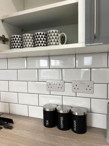 a kitchen with three trash cans on a shelf at Catherine 5 bedroom house in Crewe