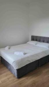 a large bed in a room with a white wall at Catherine 5 bedroom house in Crewe