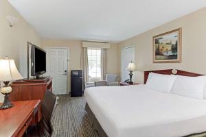 a hotel room with a large bed and a television at Baymont by Wyndham Sanford in Sanford