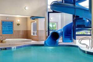 uma grande piscina com escorrega num quarto de hotel em Days Inn by Wyndham Medicine Hat em Medicine Hat
