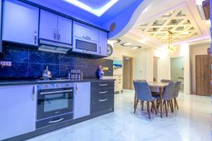 a kitchen with blue cabinets and a table with chairs at Laura Residence in Bouznika