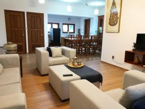 a living room with white furniture and a dining room at ANGKOR DINO B&B in Siem Reap