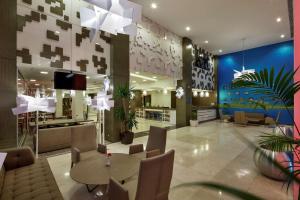 a lobby of a hotel with a table and chairs at Hampton By Hilton Gaziantep in Gaziantep