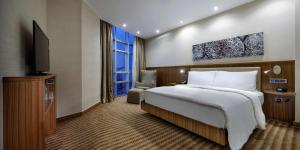 a hotel room with a bed and a television at Hampton By Hilton Gaziantep in Gaziantep