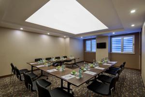 a conference room with long tables and black chairs at Hampton By Hilton Gaziantep in Gaziantep