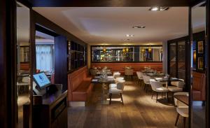 a restaurant with tables and chairs and a bar at DoubleTree by Hilton London Ealing in London