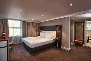 une chambre d'hôtel avec un lit et une chaise dans l'établissement DoubleTree by Hilton London Ealing, à Londres