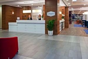 a lobby with two people standing at a counter at Hampton by Hilton Świnoujscie in Świnoujście