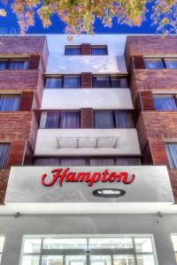 un panneau d'auberge de hampton à l'avant d'un bâtiment dans l'établissement Hampton by Hilton Świnoujscie, à Świnoujście